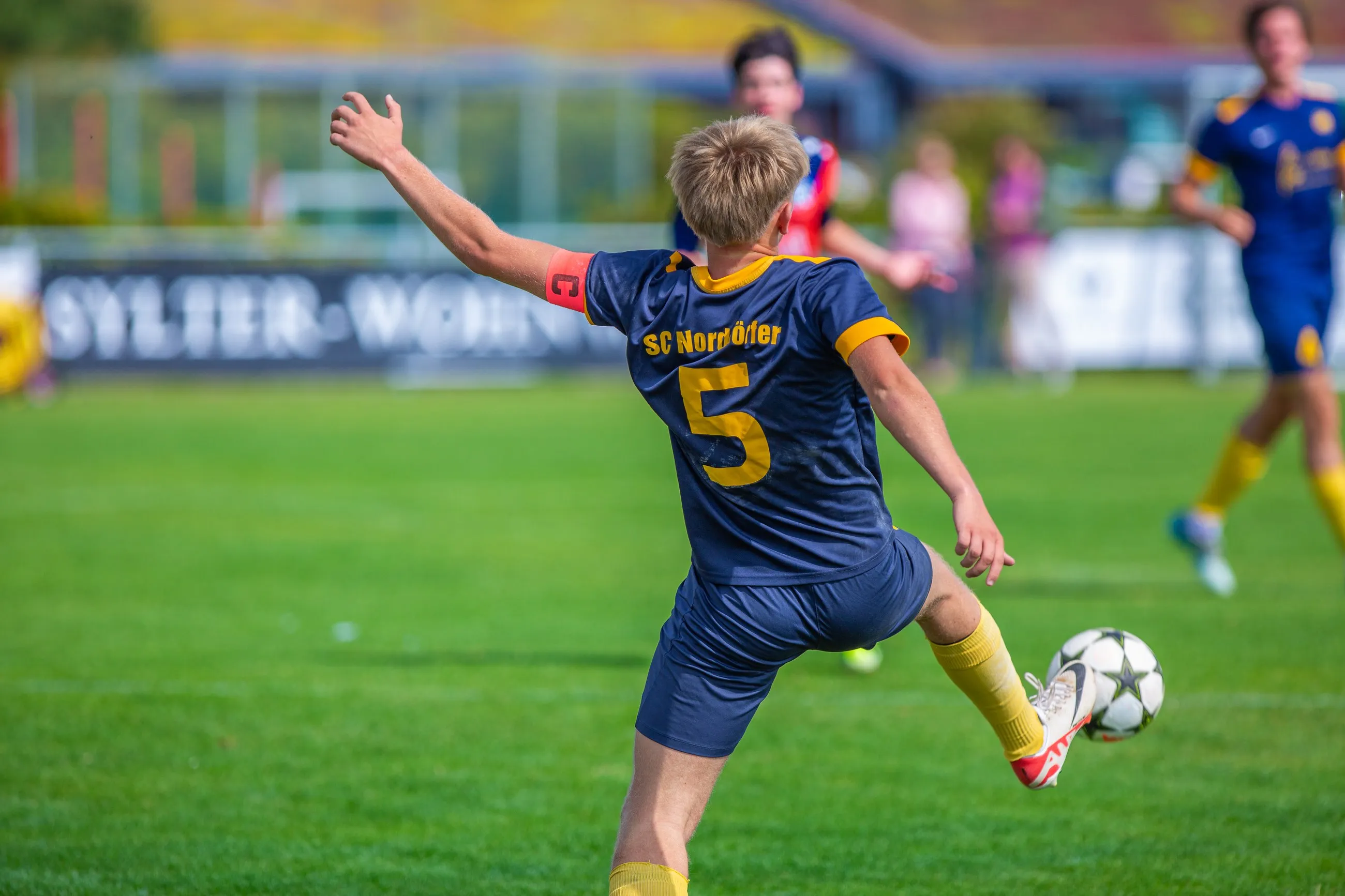 Spieler des SC Norddörfer im Trikot mit der Nummer 5 schießt den Ball